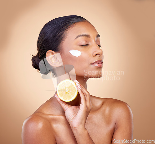 Image of Woman, lemon and cream for natural skincare, beauty product and cosmetics or vitamin c benefits and thinking. Person sleeping with face lotion, fruits and skin dermatology on brown, studio background