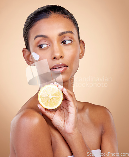 Image of Woman, thinking and cream with lemon for skincare, cosmetics and natural beauty product or vitamin c benefits. Facial sunscreen of young person with fruits for dermatology on studio, brown background