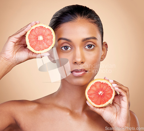 Image of Grapefruit, portrait and skincare of woman in studio for vitamin c wellness, vegan cosmetics and dermatology. Face of indian female model, natural beauty and healthy citrus for facial aesthetic shine