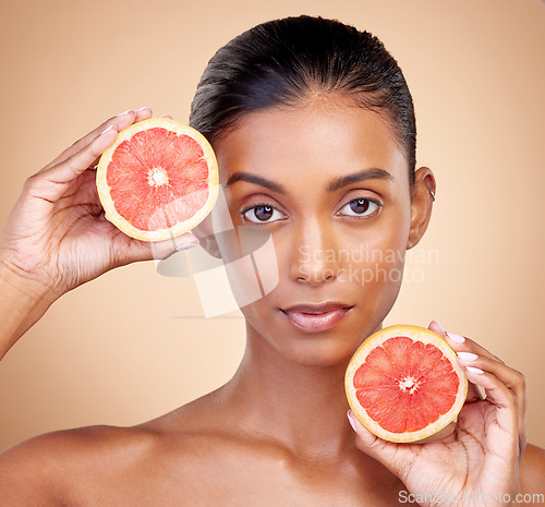 Image of Grapefruit, portrait and beauty of woman in studio for vitamin c benefits, eco cosmetics and nutrition. Face of indian female model, natural skincare and healthy citrus food for aesthetic dermatology