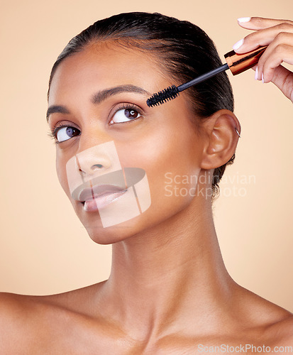 Image of Face, mascara brush and woman, beauty and makeup with cosmetics tools isolated on studio background. Indian female model, cosmetology and skin glow, shine and eyelash extension with wellness