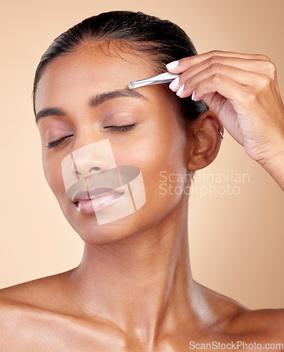Image of Beauty, face or woman with tweezers for eyebrow maintenance, hair removal or cosmetic routine. Morning self care, grooming product or relax studio person with facial plucking tool on brown background