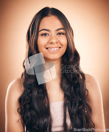 Image of Face, curly hair and beauty of woman in studio isolated on a brown background. Hairstyle, natural cosmetics and portrait of happy model with salon treatment for balayage, growth and health aesthetic