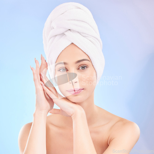 Image of Shower towel, woman and portrait in studio, blue background and natural beauty. Face of serious female model, skincare and cloth for cleaning hair, aesthetic dermatology and facial wellness in salon