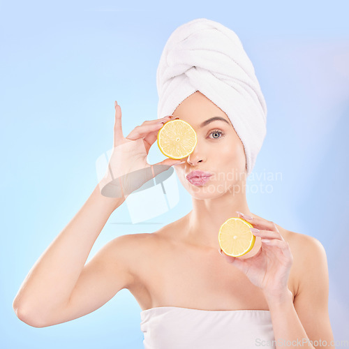 Image of Skincare, beauty and portrait of woman with lemon, makeup and facial detox with smile on blue background. Health, wellness and sustainability, model with luxuryvitamin c cleaning and towel on head.