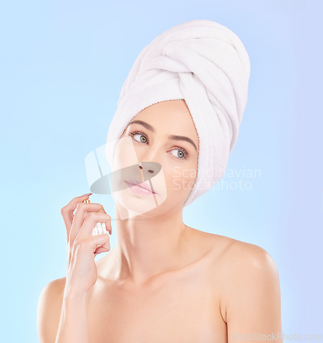 Image of Perfume, self care and young woman in a studio after a shower, health and wellness routine. Spray, beauty and female model from Australia with a clean skin treatment isolated by a blue background.