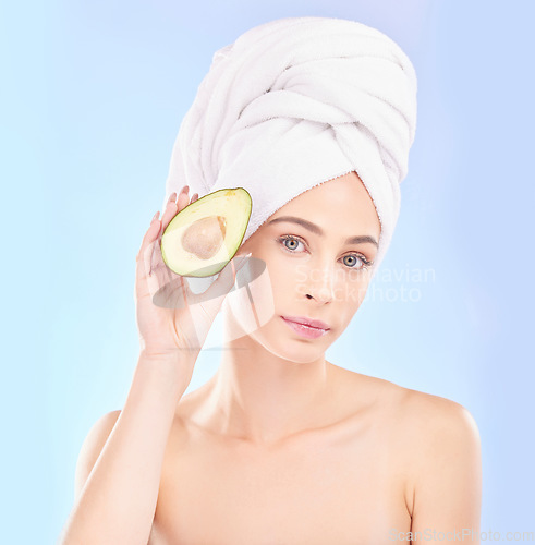 Image of Woman, portrait and avocado, natural beauty and vitamin c with sustainable skincare isolated on blue background. Face, female model with fruit and eco friendly dermatology, cosmetic care in studio
