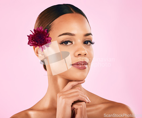 Image of Skincare, beauty and portrait of woman with flower, makeup and organic glow on pink background. Cosmetics, natural dermatology and model with facial care, nature and healthy spa aesthetic in studio.
