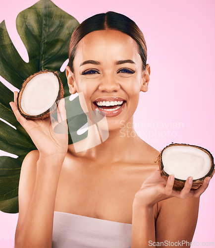 Image of Woman, smile and coconut, natural beauty and palm leaf with sustainable skincare isolated on pink background. Happiness, female model with fruit and eco friendly dermatology, cosmetic care in studio