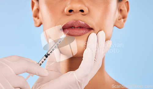 Image of Lip filler, injection and beauty, woman and cosmetic surgery closeup and dermatology on blue background. Face, skincare and syringe, female model and doctor hands with liquid collagen in studio