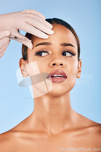 Image of Skin injection, woman and concern of plastic surgery and collagen skincare in studio. Needle, beauty and female person with blue background with cosmetics, filler and wellness for dermatology