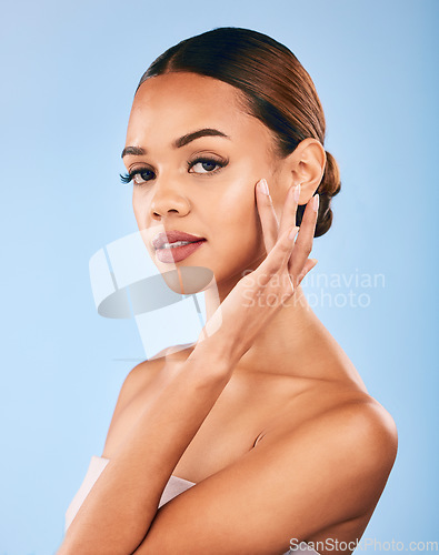 Image of Skincare, beauty and portrait of woman with makeup, wellness and glow on blue background. Cosmetics, dermatology and model with hand on face, luxury facial care and healthy spa aesthetic in studio.