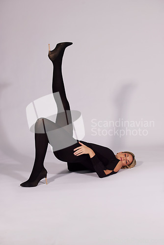 Image of Fashion, portrait and a woman with a pose on a studio background for a model aesthetic. Stylish, art and a girl or person with shoes and clothes on a backdrop for fashionable, elegant and trendy look