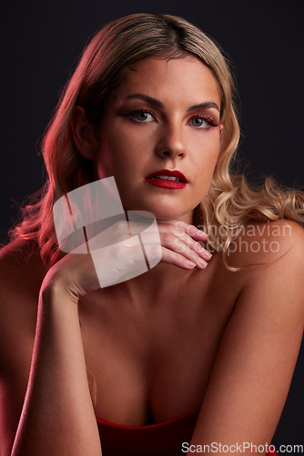 Image of Portrait, face and beauty with a woman in studio on a dark background in red lighting for desire. Skincare, makeup or cosmetics with a young female model posing for natural feminine confidence