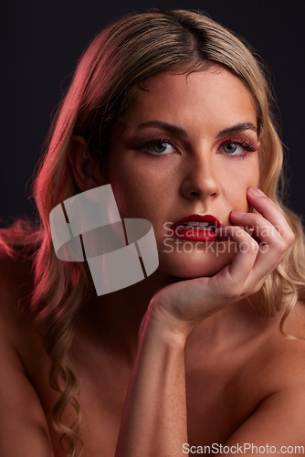 Image of Portrait, beauty and lipstick with a model woman in studio on a dark background in red lighting for desire. Face, skincare or makeup with a young female person posing for natural feminine confidence