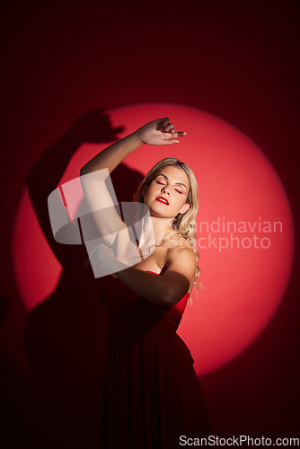 Image of Vintage, fashion and a woman in a spotlight on a studio background for an art aesthetic. Creative, retro and a young girl or rich model in a stylish dress or clothes isolated on a red backdrop