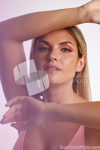 Image of Portrait, skincare and makeup with a model woman in studio on a gray background in red lighting for desire. Face, beauty or cosmetics with a young female person posing for natural feminine confidence