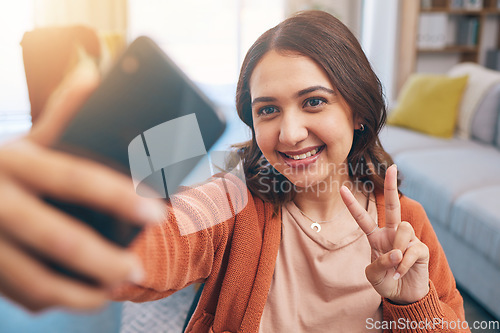 Image of Face, woman and peace for selfie with smile in home while live streaming on video call in living room. Profile picture, happy female gen z and show v sign, hand emoji and memory for social media post