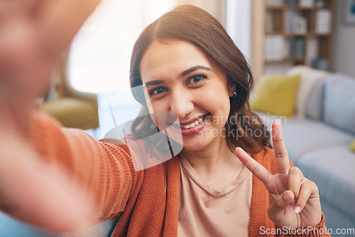 Image of Portrait, woman and peace for selfie in home, smile and fun with live streaming vlog in living room. Face, profile picture and happy female gen z show v sign, hand emoji and memory for social media