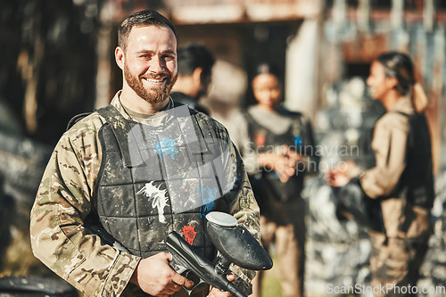 Image of Paintball game, portrait and happy man in battlefield, challenge or military mission, gun fight or conflict. Happiness, soldier smile and male player ready for war training, action or battle training