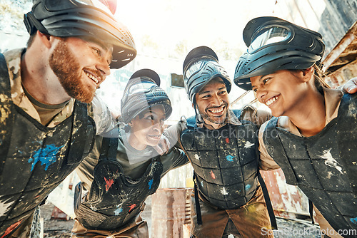 Image of Paintball, happy team and meeting in huddle for game plan, collaboration or strategy on battle field together. Group of paintballers smile in war discussion, teamwork or motivation before match start