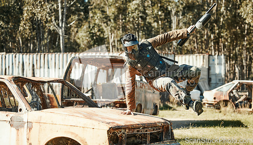 Image of Paintball game, action and man jump car, agile and run in active battlefield, military playground or training arena. Army mission, gear and person in match competition, conflict or survival challenge