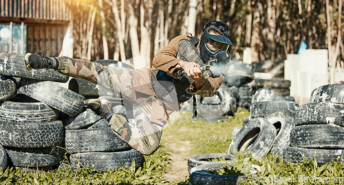 Image of Paintball, sports and man in action with gun for tournament, competition and battle in nature. Camouflage, military and male person shooting in outdoor arena for training, adventure game or challenge