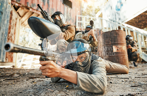 Image of Paintball, team and people in action with gun for tournament, competition and battle in nature. Sports, military and men on ground shooting in outdoor arena for training, adventure games or challenge