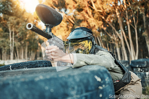 Image of Paintball, sports and person in action with gun for tournament, competition and battle in nature. Camouflage, military and woman shooting in outdoor arena for training, adventure games and challenge