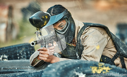 Image of Paintball, sports and woman in action with gun for tournament, competition or battle in park. Soldier, military and female person shooting in outdoor arena for training, adventure games and challenge