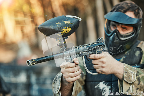 Image of Paintball, sports and man shooting with gun for tournament, competition and battle in nature. Soldier, military and male person in outdoor arena for training, adventure games and challenge for action