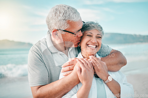 Image of Happy, kiss or old couple laughing on beach with love, care or support on summer vacation in nature. Retirement, mature man hugging or funny senior woman at sea or ocean to travel on holiday together