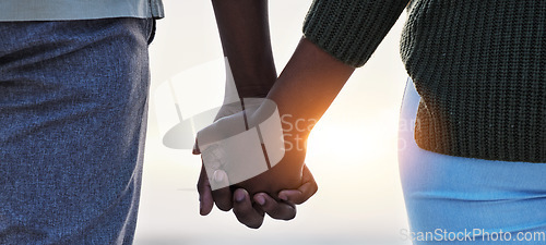 Image of Holding hands, couple and love outdoor at the beach with care, trust and commitment. Closeup of a man and woman relax together on vacation, holiday or sunset travel adventure in nature for freedom