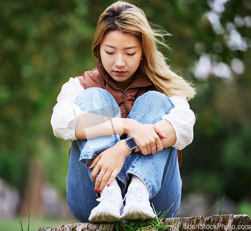 Image of Student, sad and thinking with woman in park for depression, college and anxiety. Mental health, psychology and burnout with Asian person feeling lonely in nature for fatigue, pain and grief