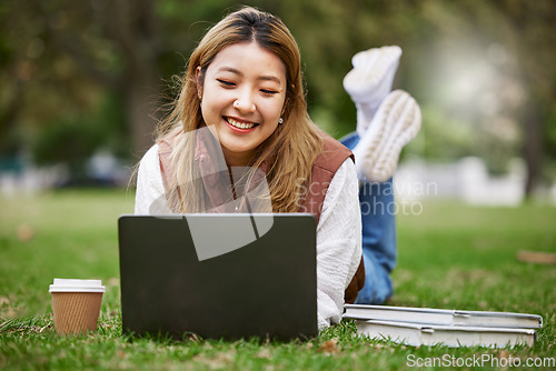 Image of Laptop, asian and woman student typing in a park to update social media while outdoor studying and learning online. Internet, web and young person working on assessment in nature for peace and calm