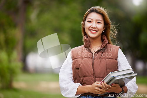Image of Asian student, portrait and woman with books for learning, education and outdoor on university campus with happiness or pride. Happy, face and girl in college with notebook or walking to class