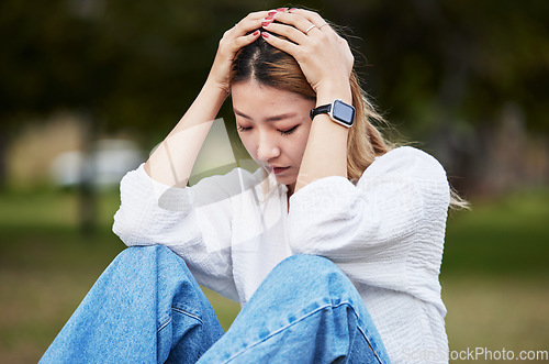 Image of Sad, depression and a woman in a park with a mental health problem, thinking and anxiety. Tired, idea and a girl or person in a garden or field with fear, anger or depressed about a mistake or fail