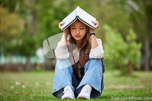 Image of Study, stress and book with woman in park for studying, thinking and depression. College, mental health and education with asian student on grass in nature for burnout, anxiety and fatigue problem