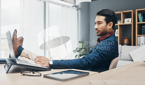Image of Relax business man with his feet up on desk working on laptop for job confidence, productivity and successful career. Serious Asian CEO, boss or professional person relaxing in office on computer
