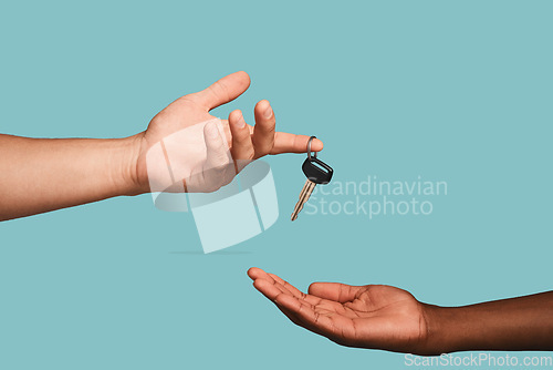 Image of Hands, key or car dealership with a salesman and customer in studio on a blue background for purchase. Transport, vehicle and deal with an automobile dealer handing keys to a consumer after a sale