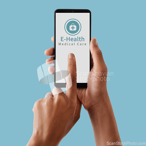 Image of Hands, phone and mockup screen for healthcare, Telehealth or medical care against a blue studio background. Hand touching smartphone display for online health advice, mobile app or communication