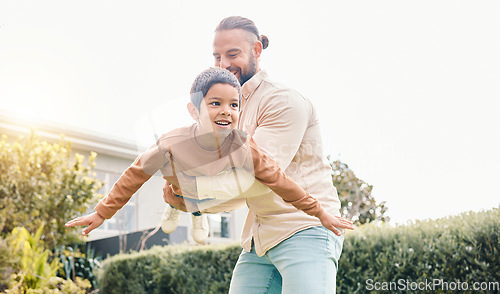 Image of Carefree, flying and playing father with a child in a garden for freedom, play and bonding. Happy, laughing and dad holding a boy kid to fly while enjoying time in the backyard of a house together