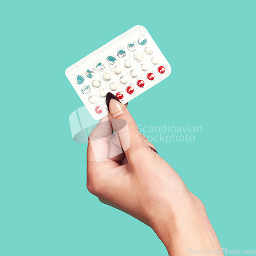 Image of Woman hands, tablets and medication for birth control on mockup against a studio background. Hand of female holding contraception, healthcare product or medical prescription for market advertising