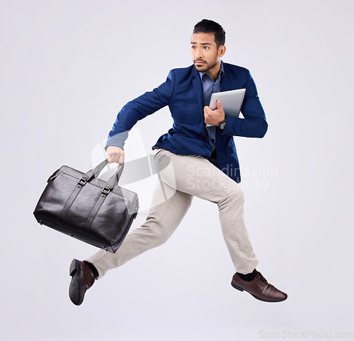 Image of Hurry, work and an Asian man jumping for business isolated on a white background in a studio. Fast, serious and a corporate Japanese businessman running in the air while late to the workplace