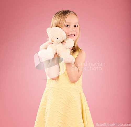 Image of Teddy bear, girl and portrait with a soft toy with happiness and love for toys in a studio. Isolated, pink background and a young female child feeling happy, joy and cheerful with stuffed friend