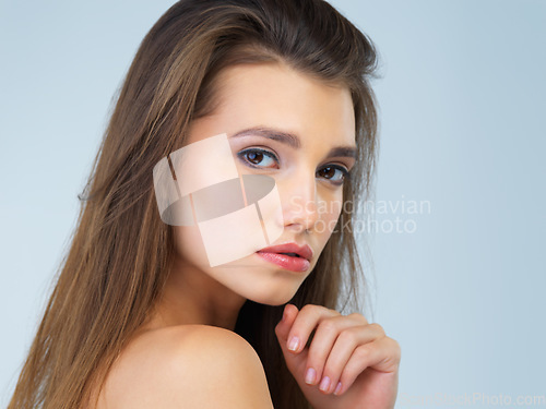 Image of Beauty, serious and portrait of woman in studio on blue background for wellness, skincare and spa treatment. Salon aesthetic, self love and face of girl with cosmetics, makeup and facial in studio