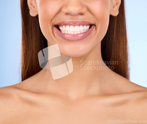 Image of Dental, teeth and smile of woman in studio for beauty, cleaning and self care. Oral hygiene, natural and cosmetic treatment with girl model isolated on blue background for veneers, fresh or results