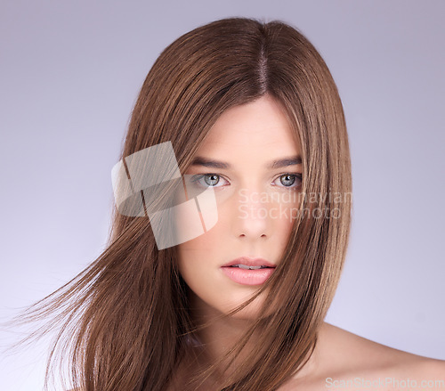 Image of Portrait, hair and wind with a model woman in studio on a gray background for haircare or keratin treatment. Shampoo, salon and beauty with an attractive young female posing in a breeze on a wall