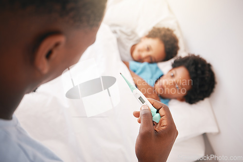 Image of Black family, father and sick kids with thermometer for checking temperature, fever or illness at home in bed. Hand of African American dad taking children temp in bedroom for healthcare diagnosis