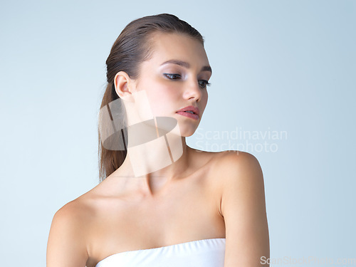 Image of Skincare, cosmetics and woman thinking, dermatology and beauty against blue studio background. Female, lady and care for confidence, daydreaming and morning routine for grooming, healthy or soft skin